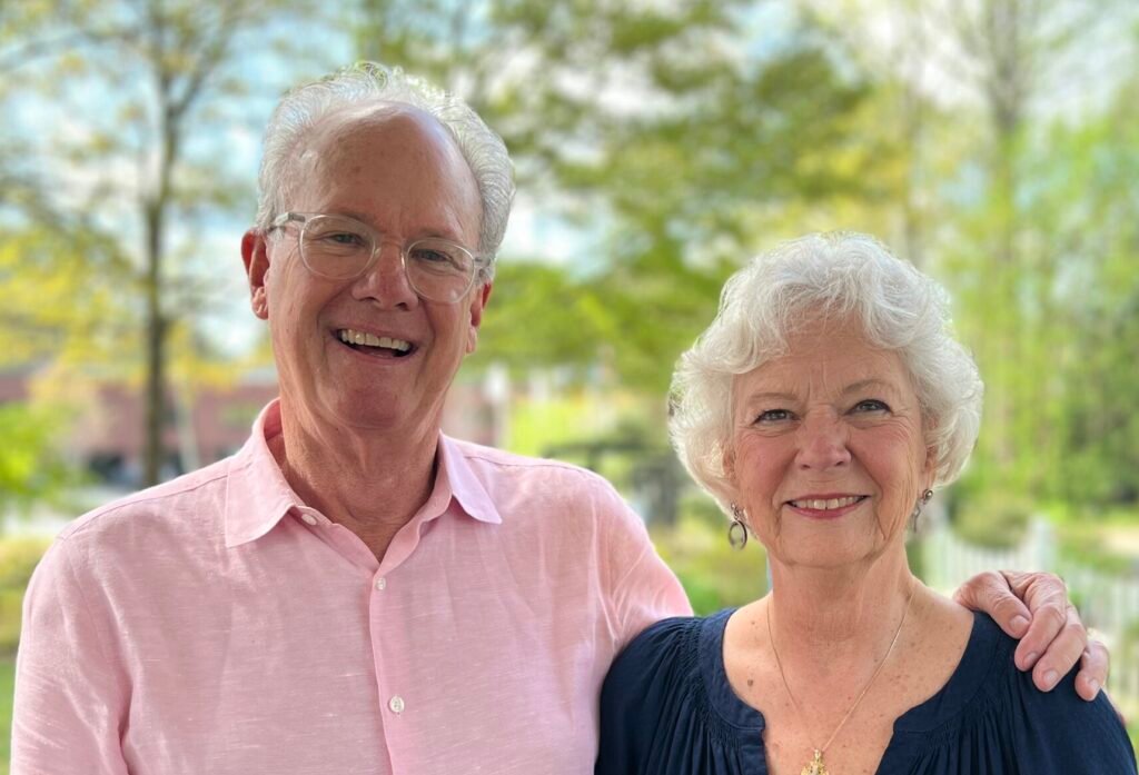 Bishop and Bevo, a posed photograph taken on a sunny day. Both are smiling and have white hair.